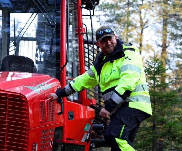 Jari Laine nousemassa metsäkoneesta tikapuita alas.