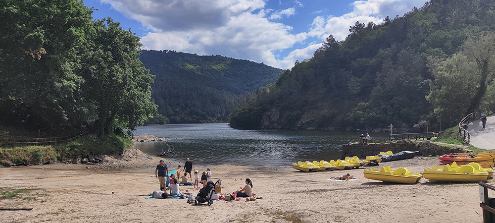 maisemakuva, ihmisiä rannalla, järvi ja vuoria