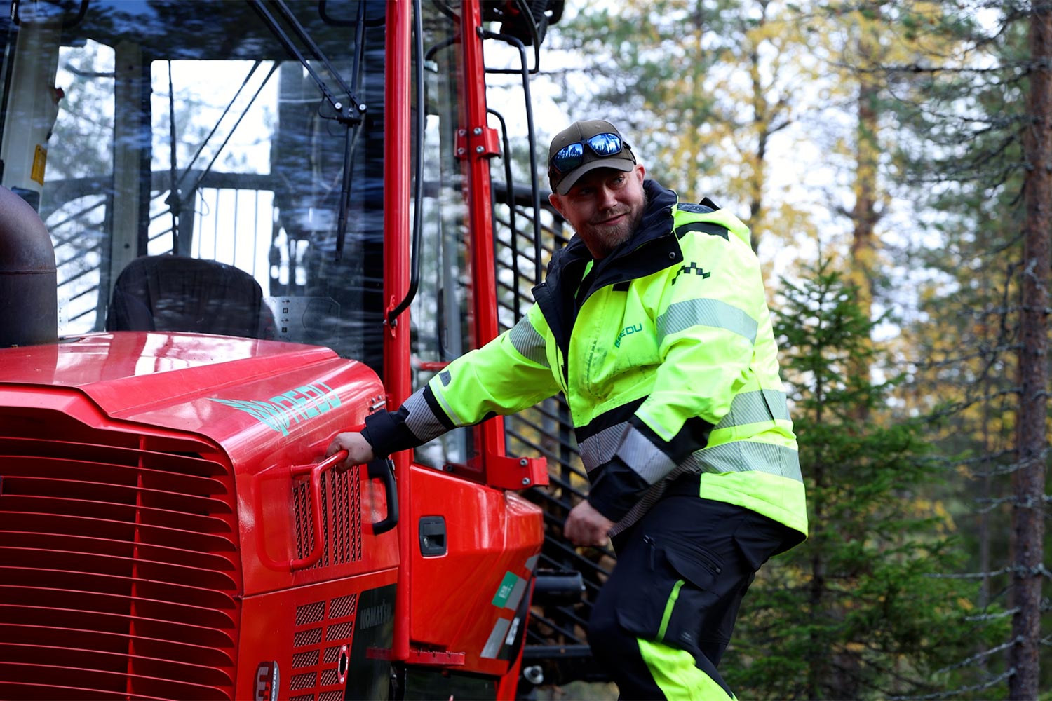 Jari Laine nousemassa metsäkoneesta tikapuita alas.
